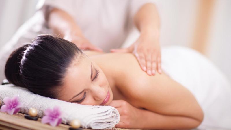 Spokojená žena si užívá masáž.
